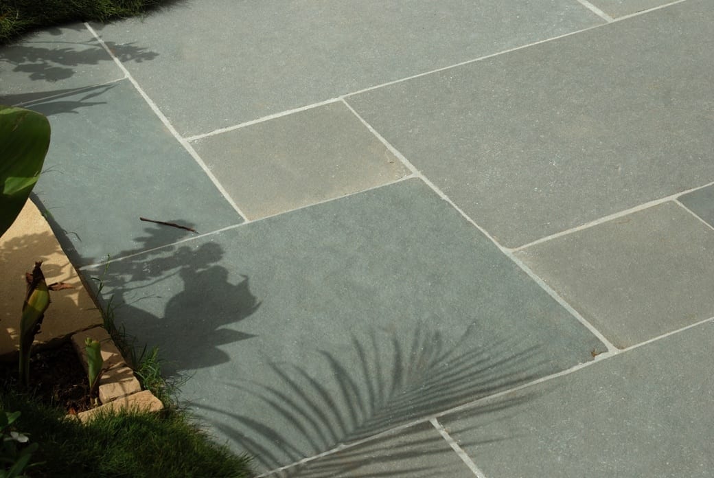 Close up photo of hand cut Tandur Grey limestone patio slabs.